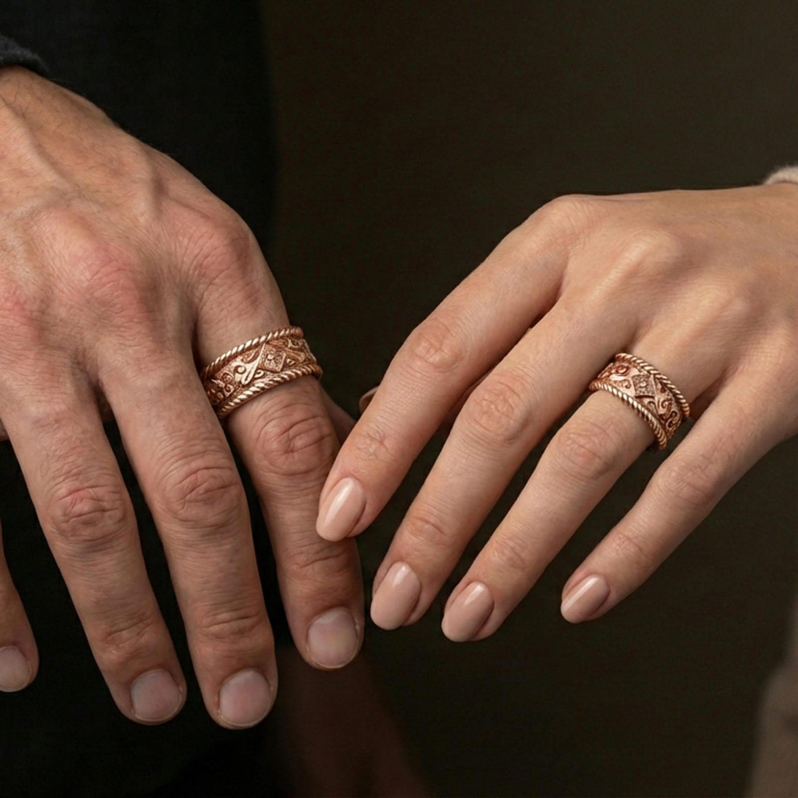 Rose gold plated rope border ring worn on finger, detailed floral and filigree engraving, elegant lifestyle wear shot.