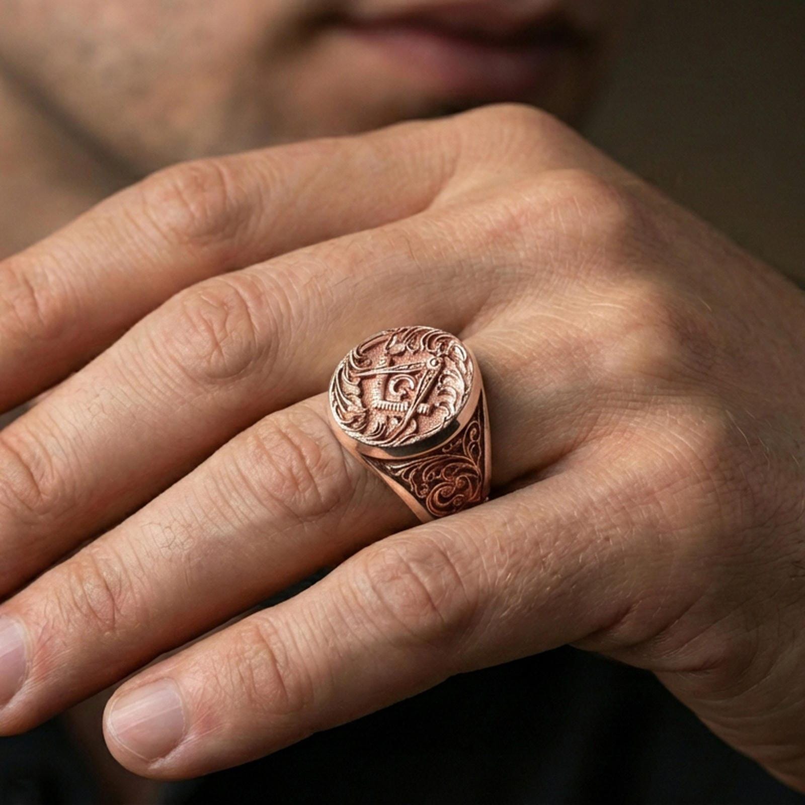 Rose gold plated Masonic signet ring on the finger, close-up lifestyle image focusing on the “G” emblem and ornate band