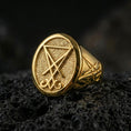 Load image into Gallery viewer, Gold plated Lucifer sigil signet ring with prominent raised occult symbol and dark textured background, macro on black volcanic rock

