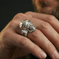 Load image into Gallery viewer, Polished silver finish skull ring on the finger, macro lifestyle photo highlighting the cap texture, glasses frame, and teeth detailing
