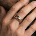 Load image into Gallery viewer, Rose gold plated spinner cloud band ring worn on finger, playful swirl relief with floral accents, elegant lifestyle wear shot.
