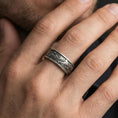 Load image into Gallery viewer, Oxidized sterling silver spinning cloud band worn on finger, whimsical swirl and flower relief detail on rotating center, natural lifestyle hand shot with shallow depth of field.
