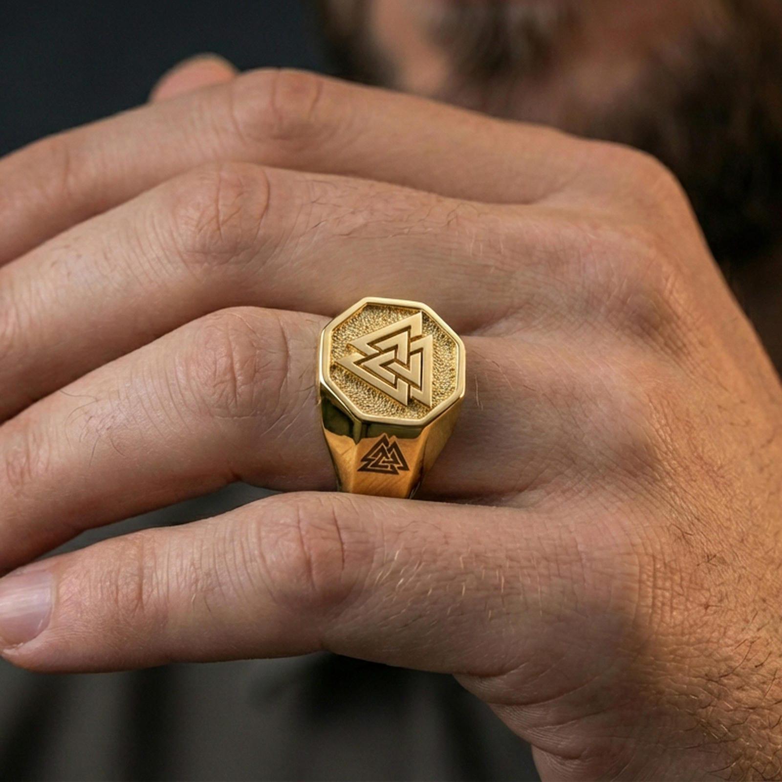 Gold plated finish Valknut signet ring worn on a finger, close-up lifestyle photo focusing on the Norse Valknut symbol and bold signet profile