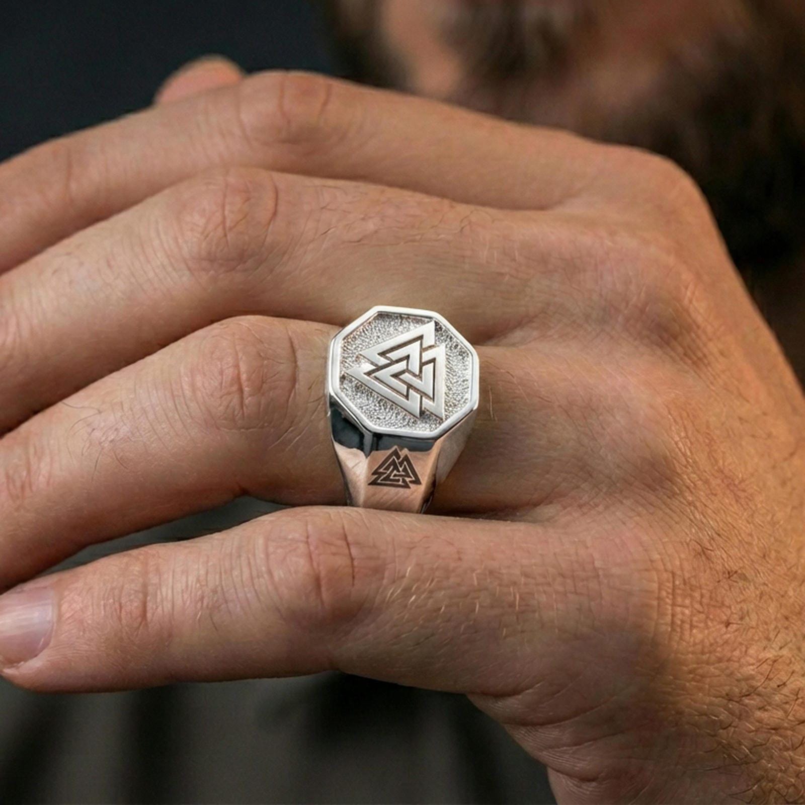 Polished silver finish Valknut signet ring on the finger, macro lifestyle image highlighting the geometric octagon face and Viking emblem details
