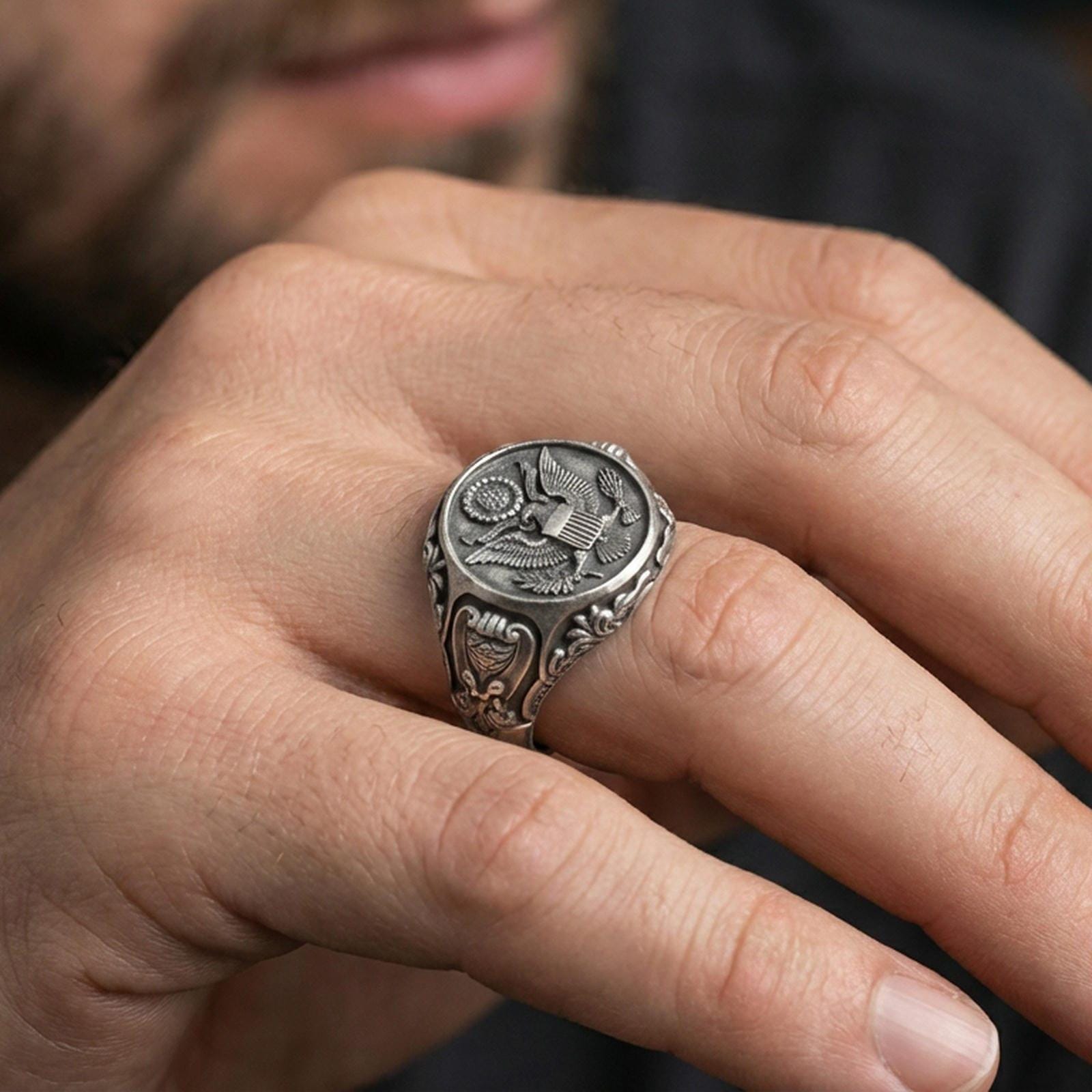 Oxidized finish US eagle seal signet ring worn on a finger, close-up lifestyle shot highlighting the engraved emblem and bold signet profile