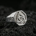 Load image into Gallery viewer, Sterling silver triquetra signet ring in a polished silver finish, octagon signet face with crisp Celtic trinity knot, close-up on volcanic stone

