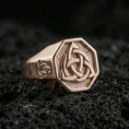 Load image into Gallery viewer, Sterling silver triquetra signet ring with a rose gold plated finish, octagon signet face featuring a triquetra Celtic knot, close-up on volcanic rock
