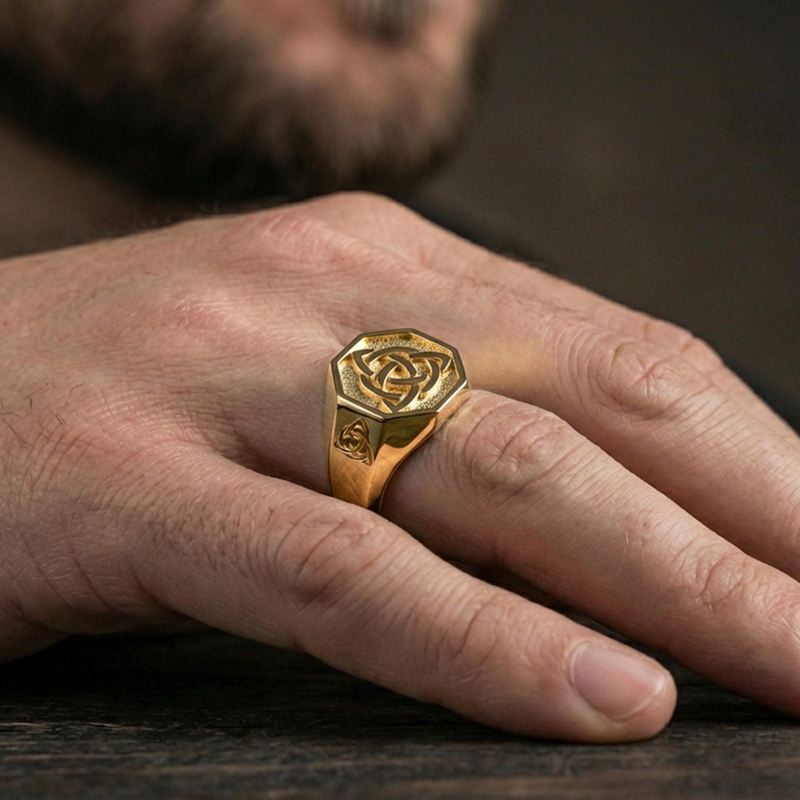 Gold plated finish sterling silver triquetra signet ring worn on a finger, close-up lifestyle photo emphasizing the bold octagon face and shine