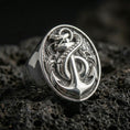 Load image into Gallery viewer, Sterling silver anchor and snake signet ring in a polished silver finish, detailed nautical anchor motif with coiled serpent, close-up on volcanic stone
