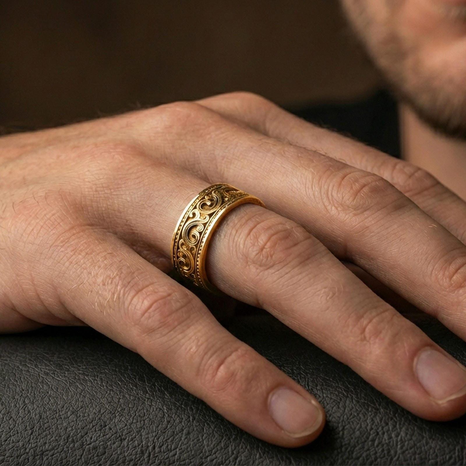 Gold plated scrollwork engraved band worn on finger, detailed swirl motif and beaded border trim, premium lifestyle jewelry photo.