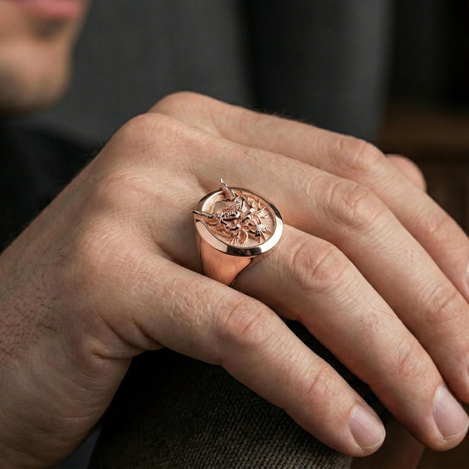 Rose gold plated oni mask signet ring on the finger, close-up showing the bold gothic statement profile