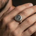 Load image into Gallery viewer, Oxidized finish sterling silver Roman coin signet ring worn on a finger, close-up lifestyle shot highlighting the emperor profile and vintage patina

