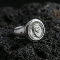 Load image into Gallery viewer, Sterling silver Roman coin signet ring in a polished silver finish, raised imperial portrait seal with circular inscription detail, close-up on volcanic stone
