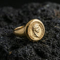 Load image into Gallery viewer, Sterling silver Roman coin signet ring with a gold plated finish, antique coin-style emperor profile and engraved rim text, macro on volcanic rock
