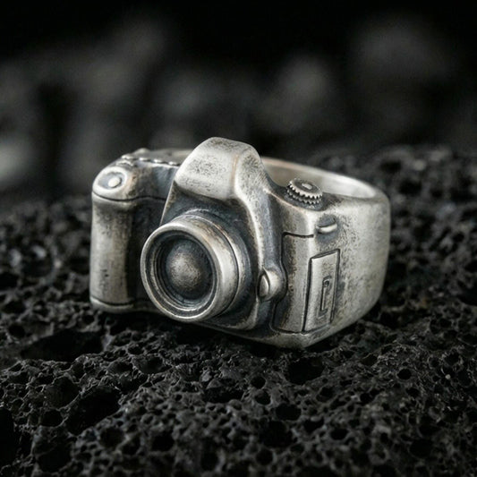 Sterling silver camera signet ring with an oxidized finish, 3D vintage camera design with lens detail, macro on black volcanic rock