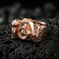 Load image into Gallery viewer, Sterling silver camera signet ring with a rose gold plated finish, vintage camera ring with dimensional lens and button details, close-up on volcanic rock
