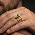 Load image into Gallery viewer, Gold plated biker skull ring worn on finger, detailed helmet skull with engine wing accents, premium lifestyle jewelry photo.
