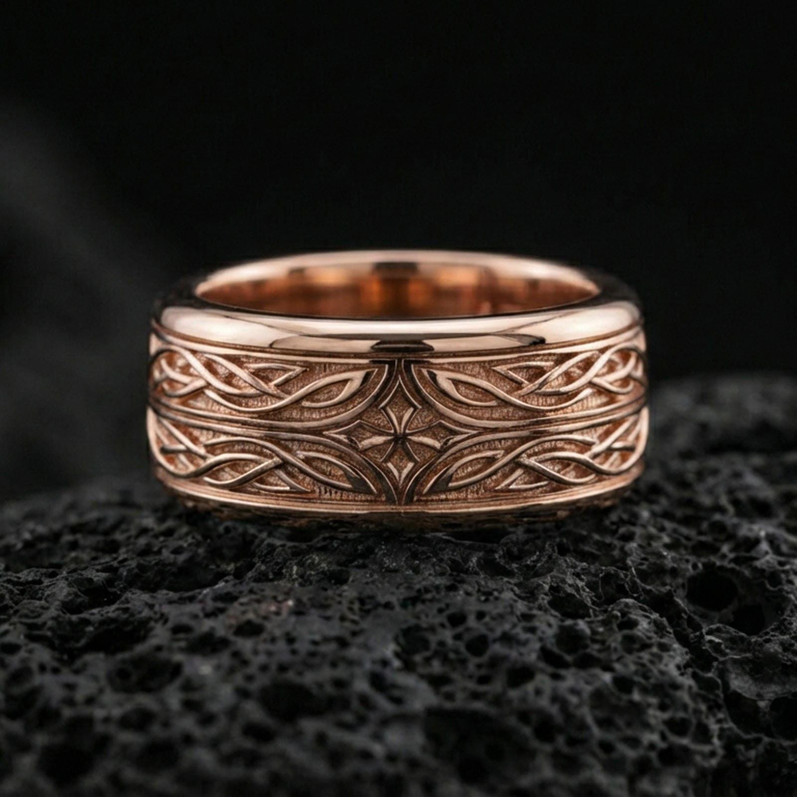 Rose gold plated sterling silver elven star spinner ring on volcanic stone, ornate knotwork engraving with central star detail and deep contrast, minimal high-end close-up.