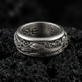 Load image into Gallery viewer, Oxidized sterling silver koi fish spinner band ring on dark volcanic rock, detailed koi and wave engraving on rotating center, premium macro product shot.

