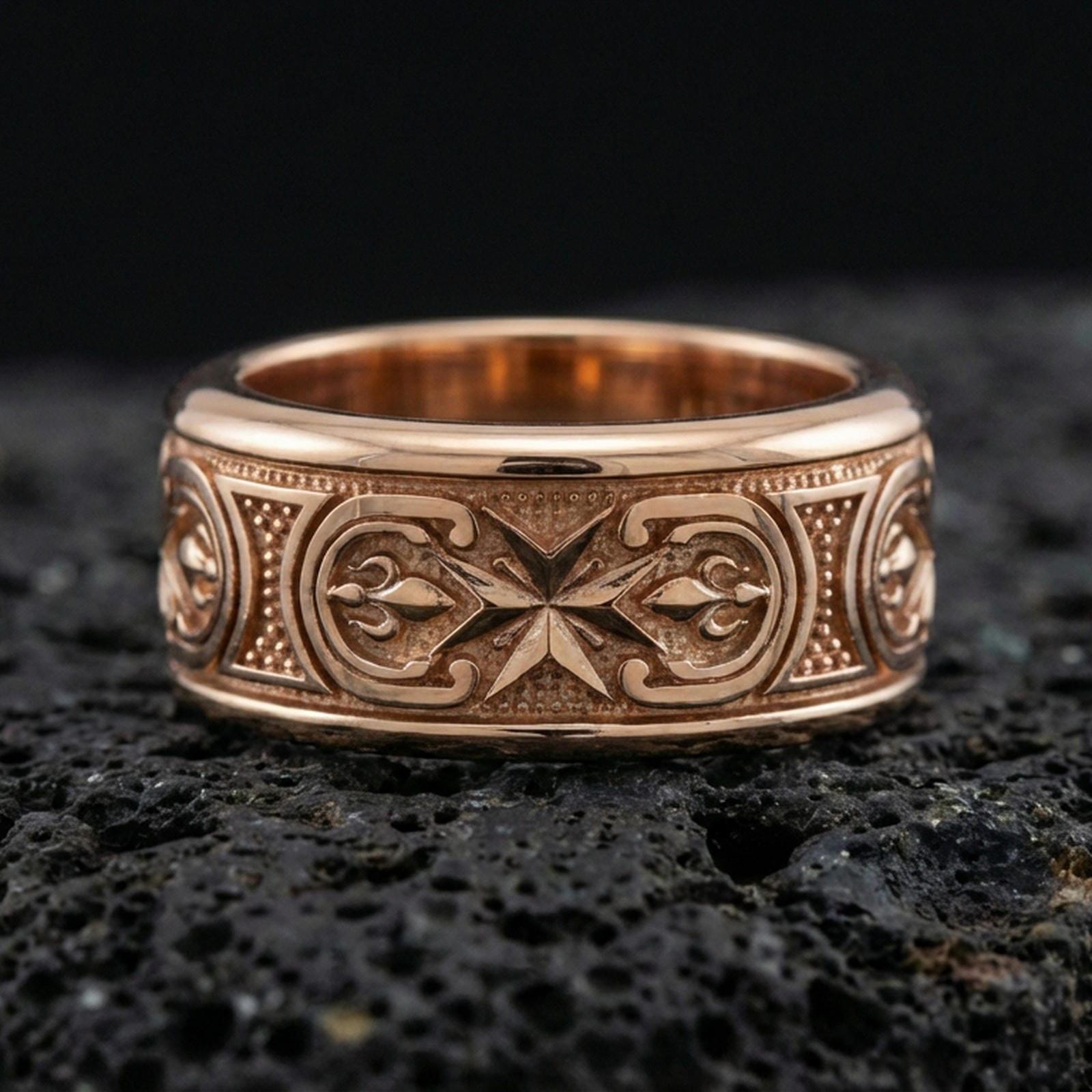 Rose gold plated sterling silver Maltese cross spinner ring on volcanic stone, sculpted cross relief with deep contrast and decorative borders, minimal high-end close-up.