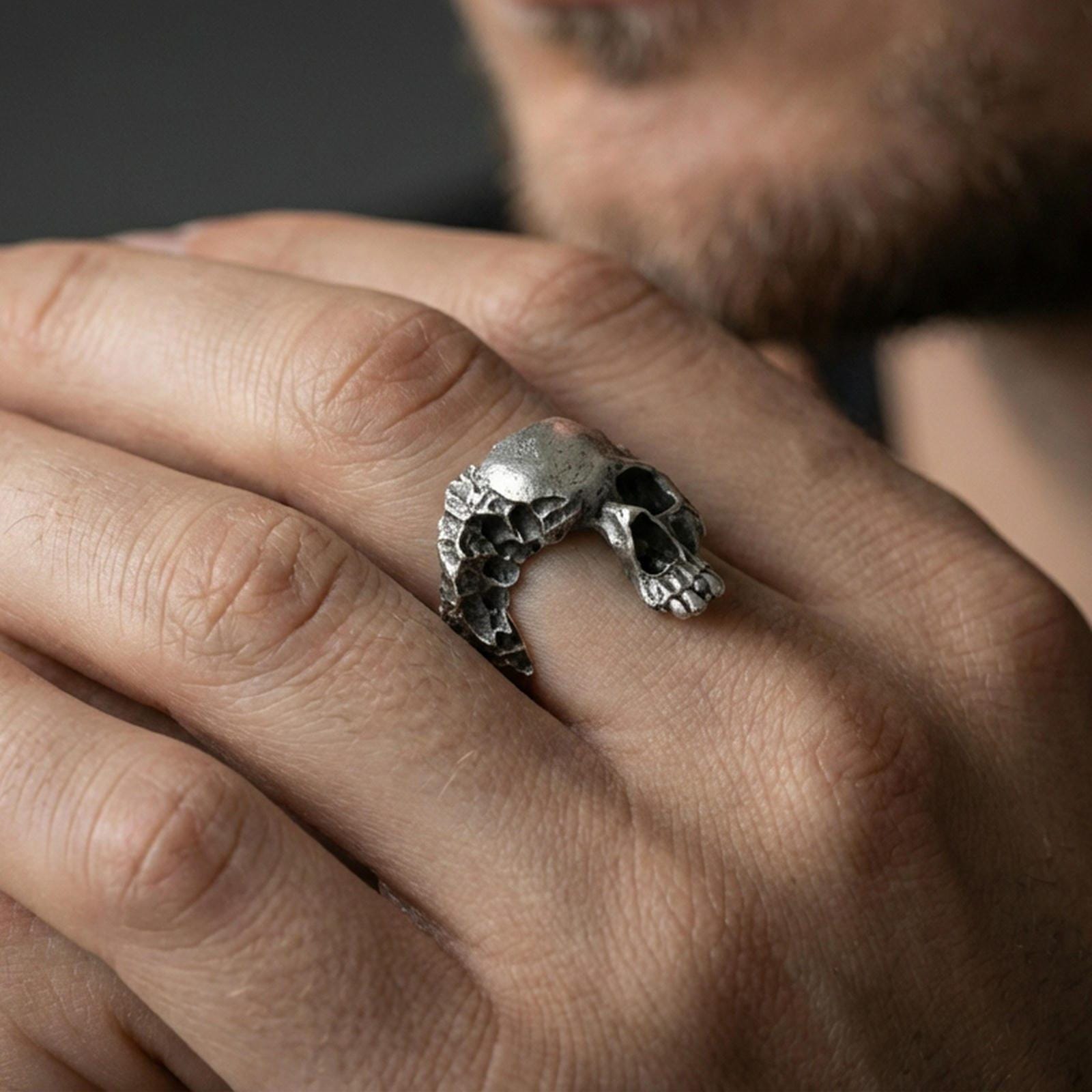 Oxidized finish sterling silver shattered skull ring worn on a finger, close-up lifestyle shot highlighting the openwork skull design and rugged gothic texture