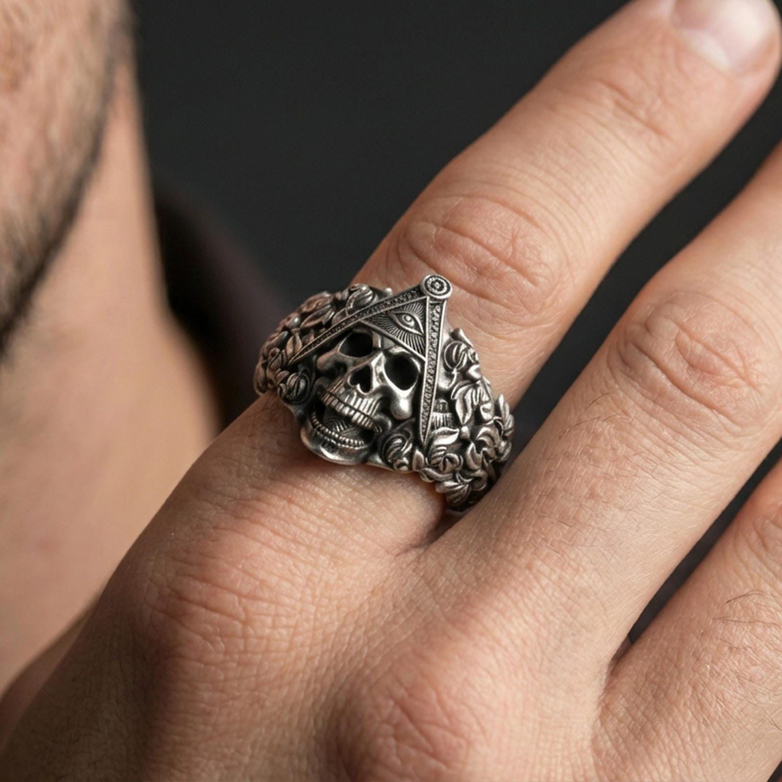 Oxidized finish sterling silver Masonic skull ring worn on a finger, close-up lifestyle shot highlighting the all-seeing eye triangle and gothic skull detailing