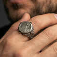 Load image into Gallery viewer, Sterling silver all-seeing eye pyramid signet ring worn on a finger, close-up lifestyle shot highlighting the oxidized symbolic engraving and ornate side details
