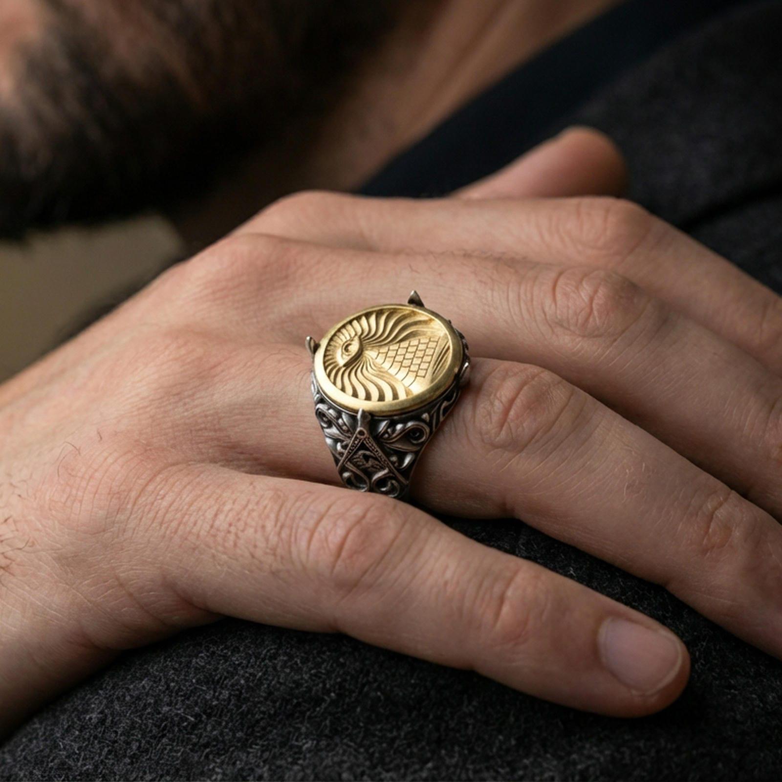 Sterling silver all-seeing eye pyramid signet ring worn on a finger, close-up lifestyle shot highlighting the oxidized body and gold plated front symbolic engraving and ornate side details