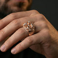 Load image into Gallery viewer, Sterling silver hoplite warrior statement ring on a finger, macro lifestyle shot featuring the rose gold plated finish and intricate shield-and-sword battle motif
