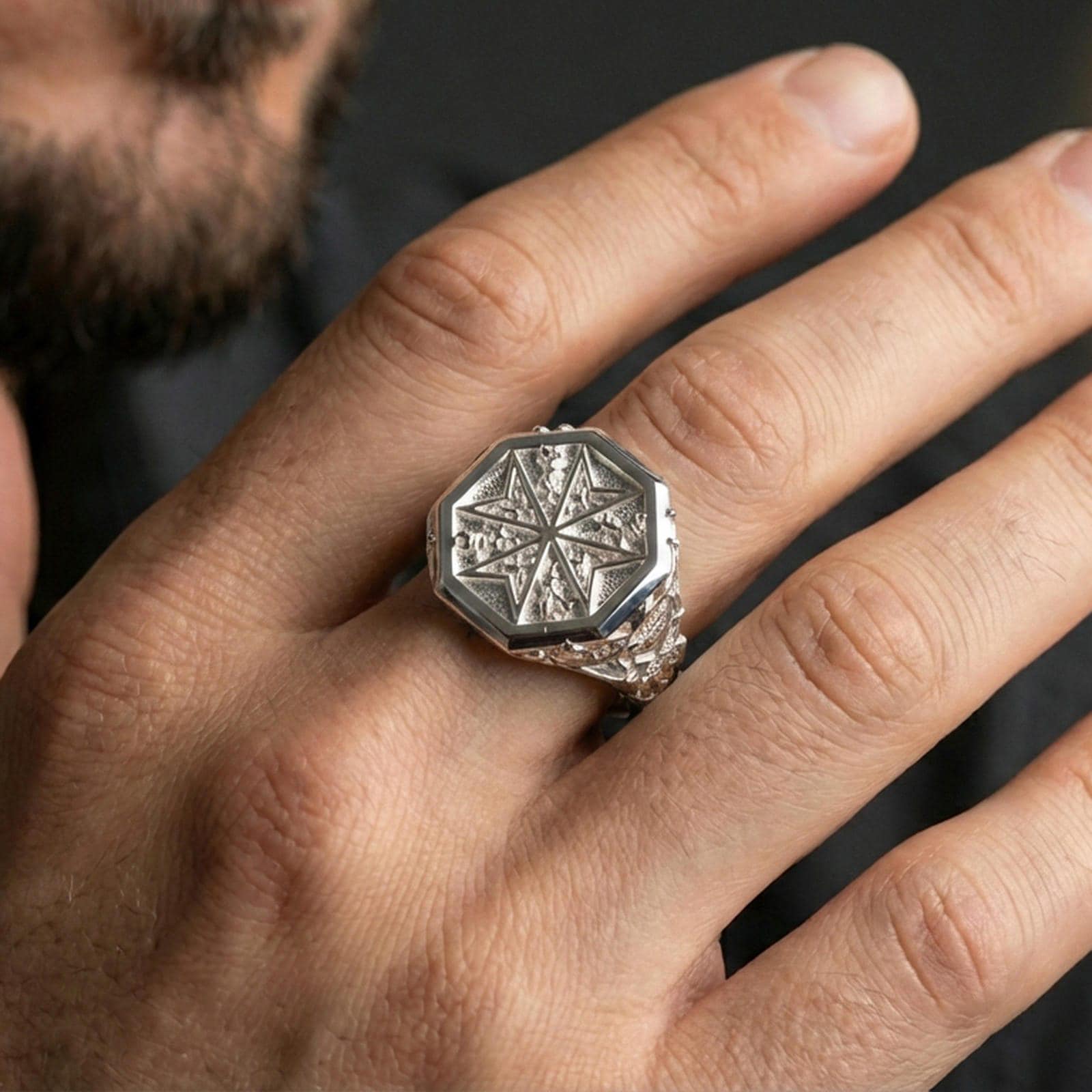Sterling silver octagonal cross ring on a finger, macro lifestyle image emphasizing the polished silver finish and engraved ornamental band details