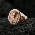 Load image into Gallery viewer, Sterling silver Egyptian king signet ring with a rose gold plated finish, bold oval statement face with pharaoh bust engraving and symbolic ankh detail, close-up on black volcanic rock
