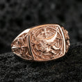 Load image into Gallery viewer, Sterling silver medieval heraldry ring with a rose gold plated finish, detailed Lion of Judah emblem and cross accents on a square signet face, close-up on black volcanic rock
