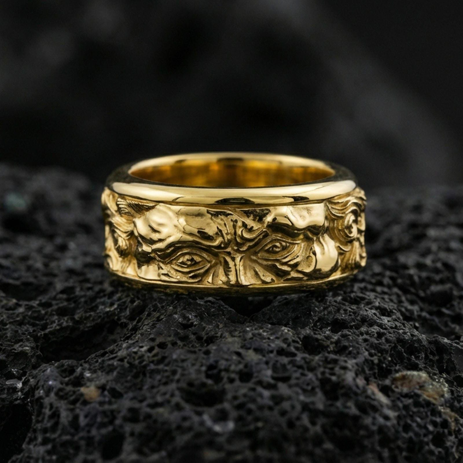 Gold plated Michelangelo Moses spinner band ring on volcanic rock, detailed portrait relief on rotating band with vintage scroll accents, luxury jewelry product photography.