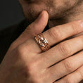 Load image into Gallery viewer, Rose gold plated Moses spinner ring worn on finger, sculpted Renaissance portrait relief detail, elegant lifestyle wear shot.
