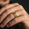 Load image into Gallery viewer, Gold plated arrowhead spinner band worn on finger, detailed tribal arrow pattern on rotating band, premium lifestyle jewelry photo.
