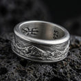 Load image into Gallery viewer, Oxidized sterling silver mountain range band ring on dark volcanic rock, rugged alpine skyline engraving with deep contrast, premium macro product shot.
