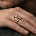 Load image into Gallery viewer, Sterling silver mummy mask statement ring on a finger, macro lifestyle shot featuring the rose gold plated finish and bold ancient Egyptian horror motif
