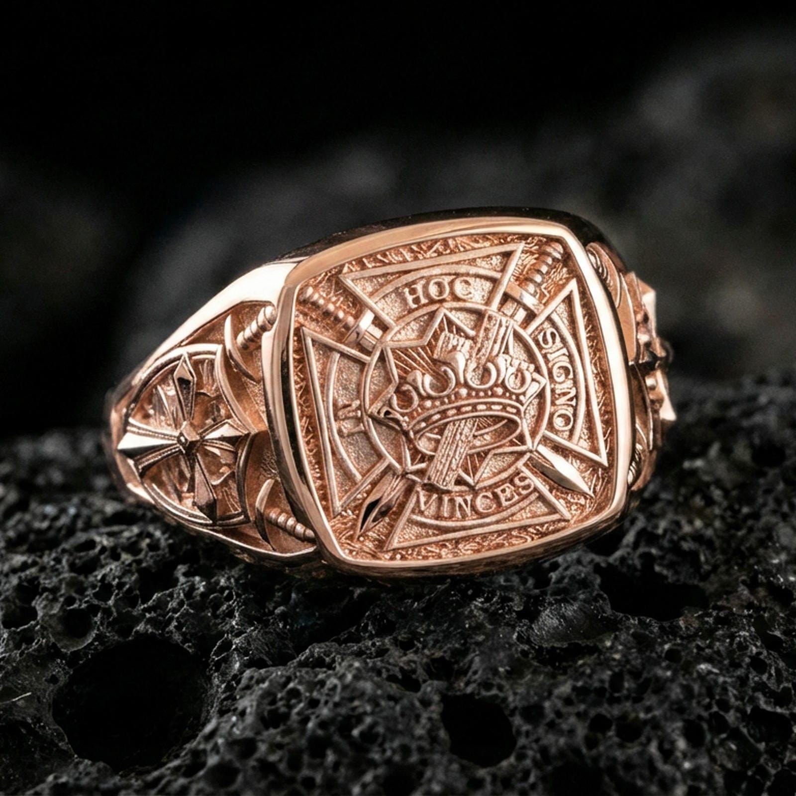 Sterling silver Templar symbolism ring with a rose gold plated finish, engraved crusader shield design with ornate side cross details, close-up on black volcanic rock