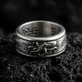 Load image into Gallery viewer, Oxidized sterling silver octopus spinner band ring on dark volcanic rock, raised octopus relief on rotating center with ocean texture, premium macro product shot.
