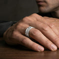 Load image into Gallery viewer, Polished silver floral engraved band ring on finger, crisp daisy relief and swirling botanical pattern, refined everyday wear close-up.
