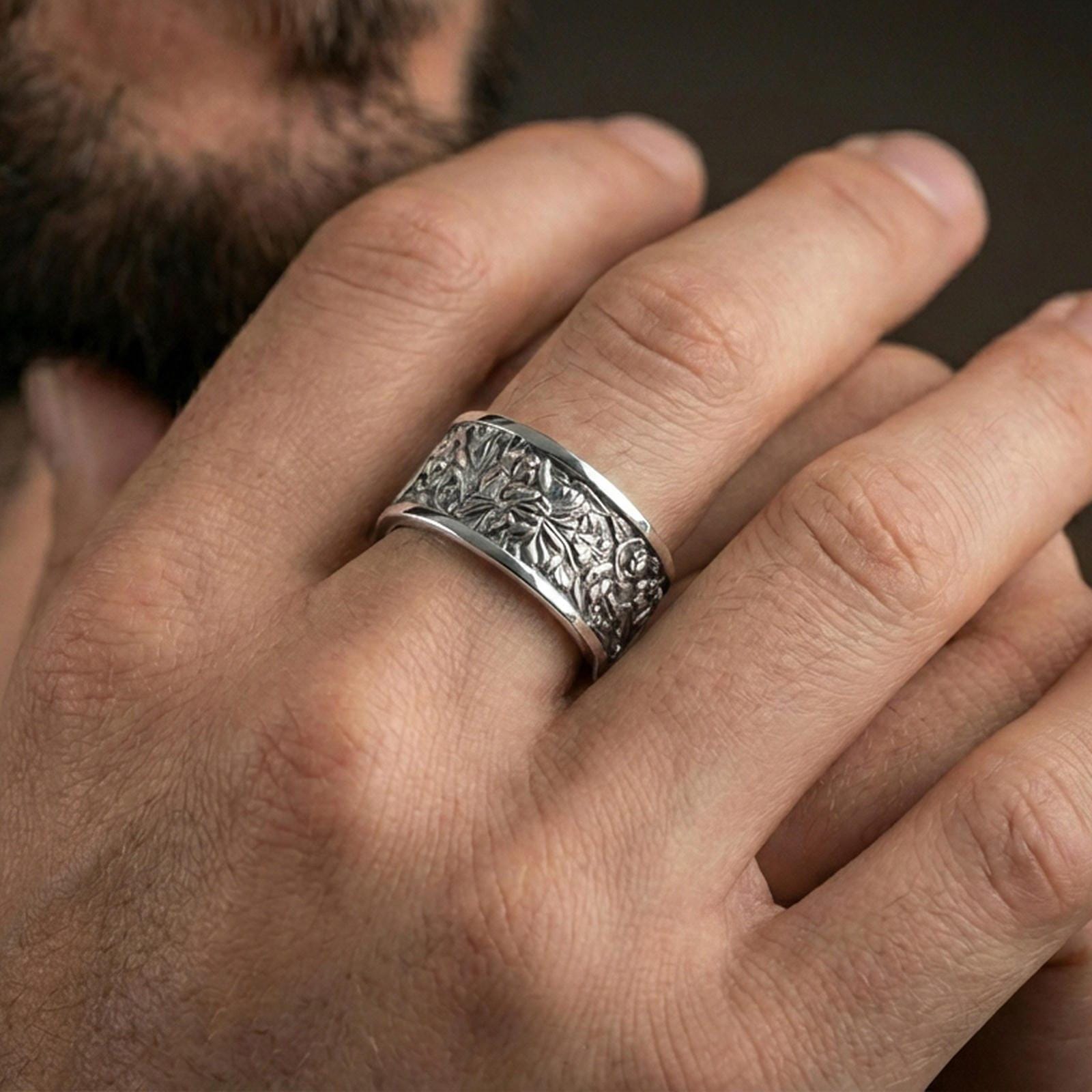 Polished silver nature wildlife engraved band ring on finger, crisp jungle scene relief with botanical detail, refined everyday wear close-up.