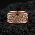 Load image into Gallery viewer, Rose gold plated sterling silver jungle scene band on volcanic stone, sculpted foliage and wildlife relief with deep contrast, minimal high-end close-up.
