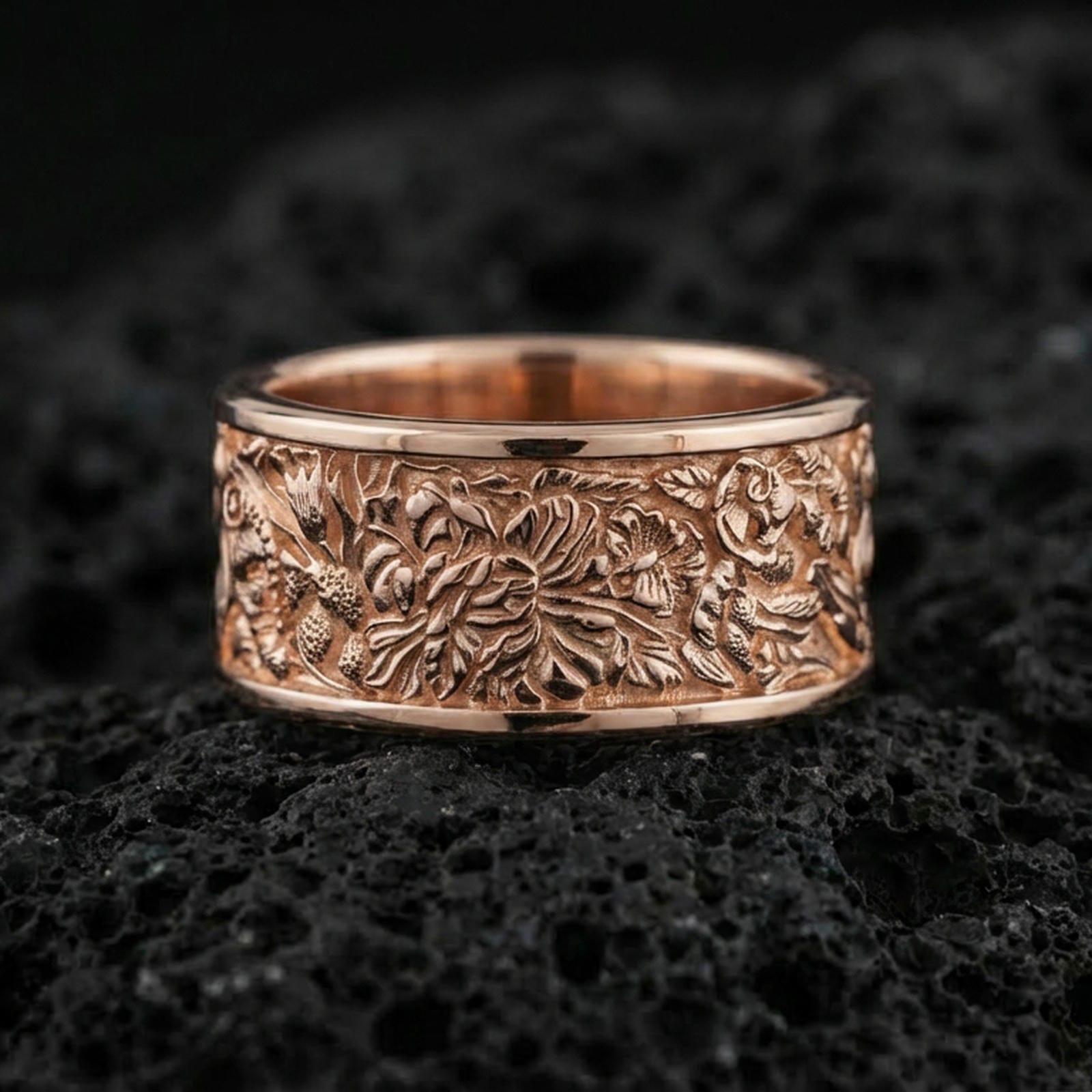 Rose gold plated sterling silver jungle scene band on volcanic stone, sculpted foliage and wildlife relief with deep contrast, minimal high-end close-up.