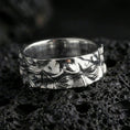 Load image into Gallery viewer, Polished silver Moses fidget spinner ring on black volcanic stone, crisp sculpted face relief with ornamental scroll side detail, centered close-up studio lighting.

