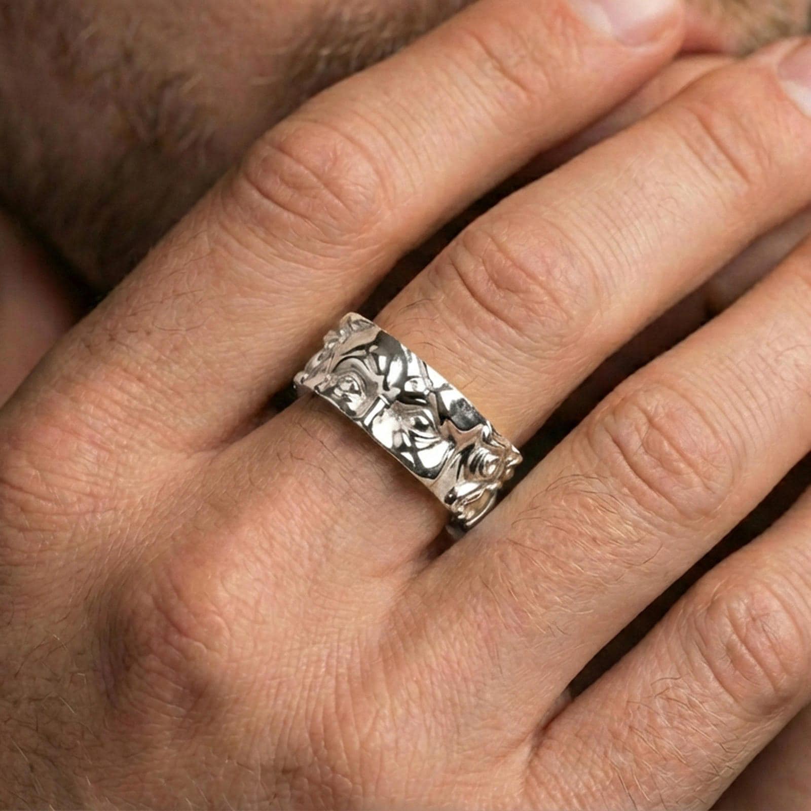 Polished silver Moses fidget spinner ring on finger, crisp face relief and ornamental side detail, refined everyday wear close-up.