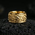 Load image into Gallery viewer, Gold plated swirling flames band ring on volcanic rock, detailed fire wave relief with bold sculpted depth, luxury jewelry product photography.
