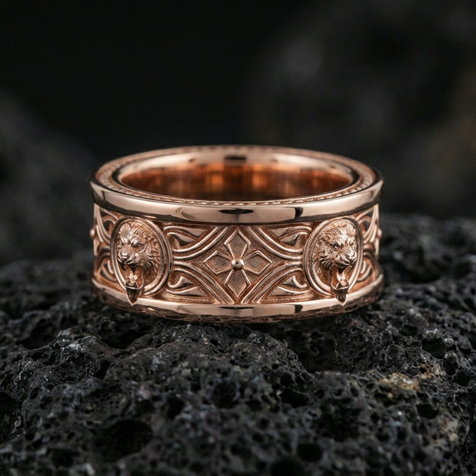 Rose gold plated sterling silver lion crest band on volcanic stone, sculpted lion head relief medallions with ornate cross motif in deep contrast, minimal high-end close-up.