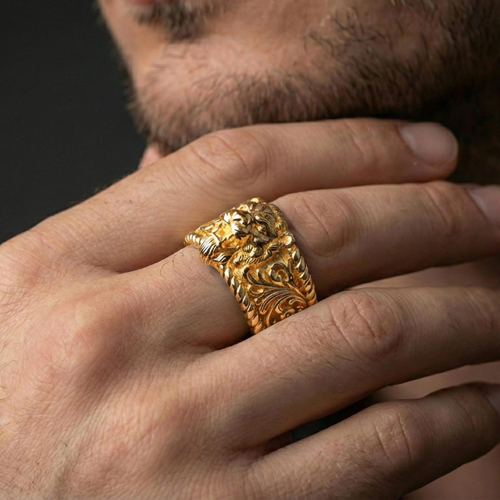 Gold plated lion head signet worn on finger, detailed roaring lion relief with baroque scrollwork shoulders, premium lifestyle jewelry photo.