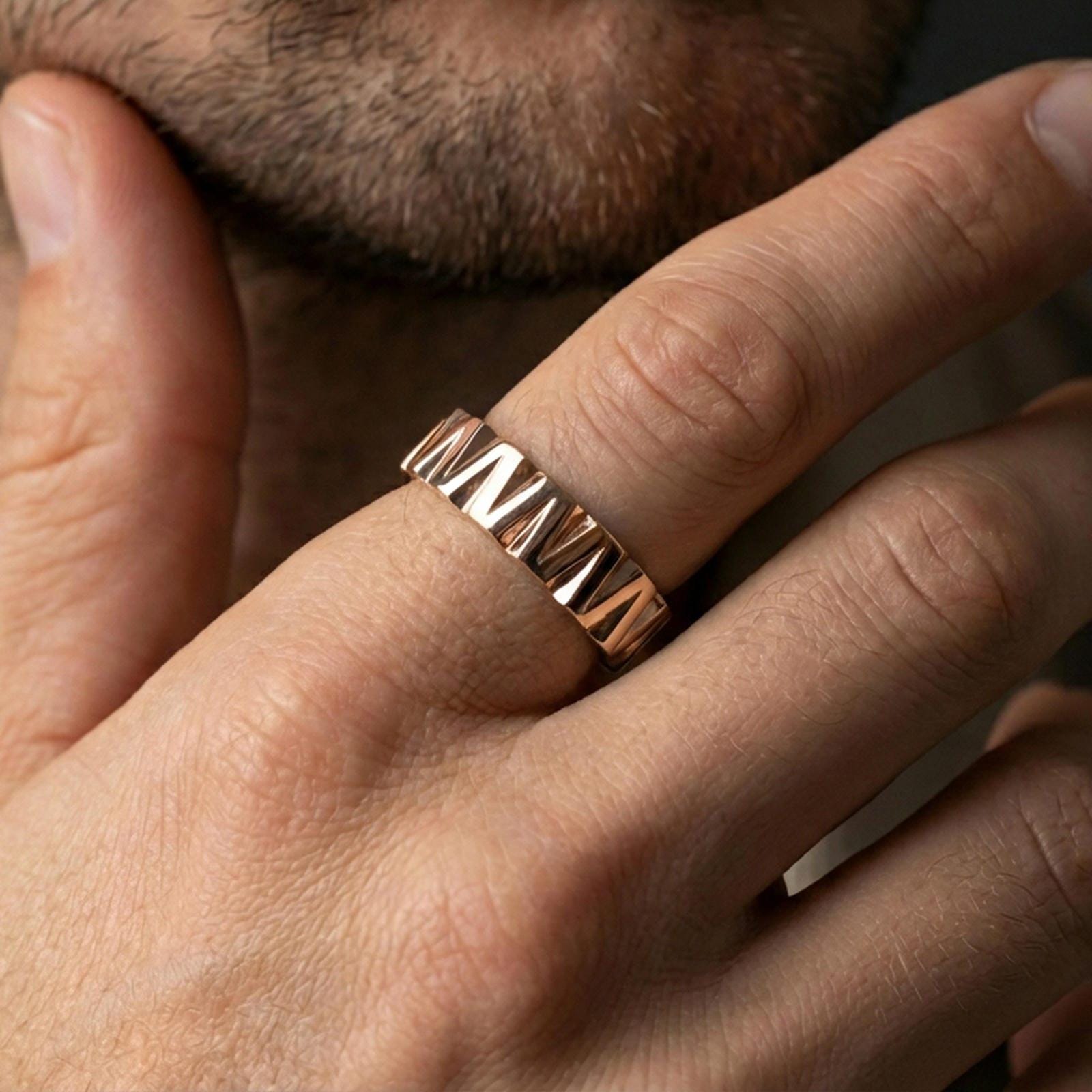 Rose gold plated faceted geometric band ring worn on finger, sculpted wedge pattern with elegant contrast, refined lifestyle wear close-up.