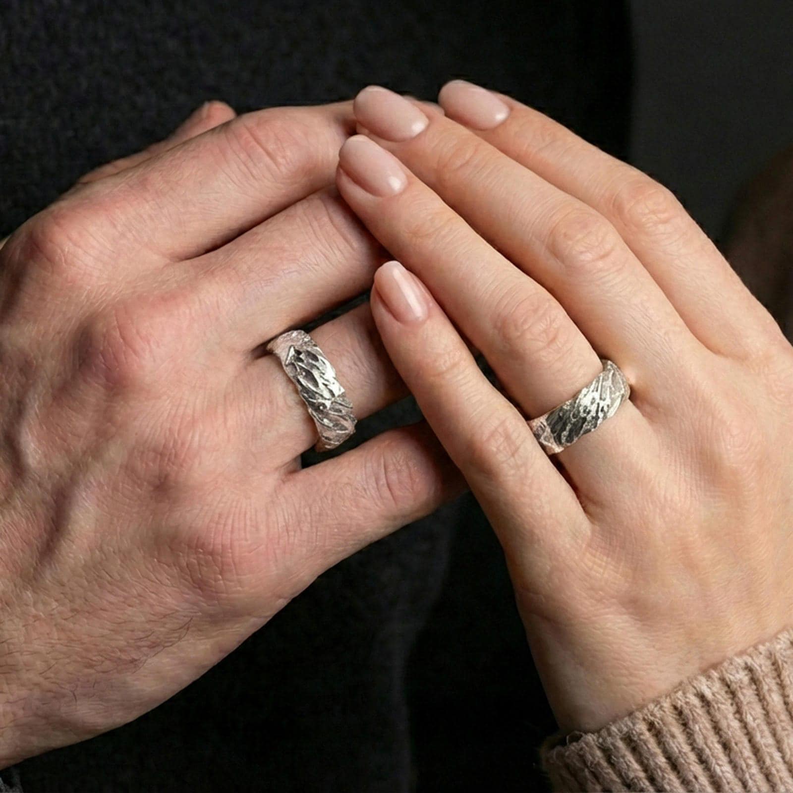 Polished silver hammered organic ring worn on finger, clean reflective finish emphasizing the stone-like surface texture, daily wear shot.